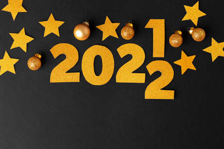 Concept of the year 2022. Golden stars and numbers 2022 on paper background
