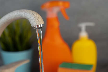 Household chemicals product bottles standing near the kitchen sinkの写真素材