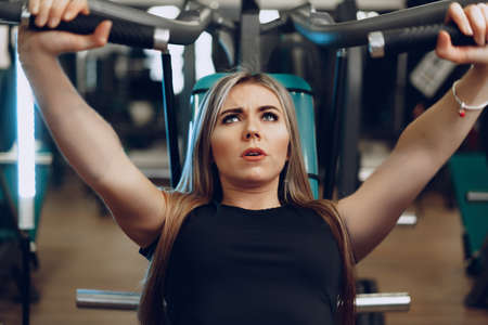 Young blonde woman fitness coach doing hands workout