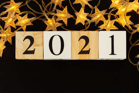 Concept of the year 2021. Golden stars with 2021 numbers on paper background