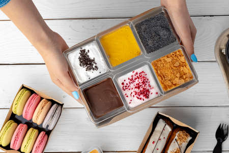 Assortment of delicious dessert boxes on wooden table