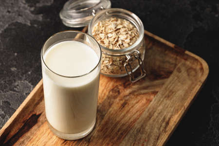 Vegan oat milk with oat flakes close upの写真素材