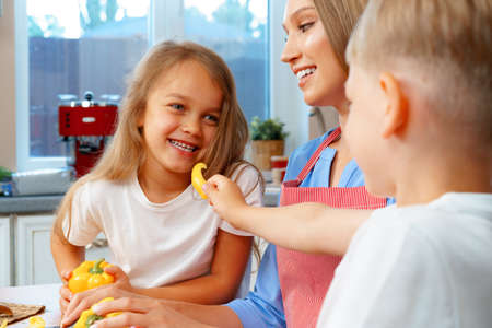 Mother cooking with her children in kitchenの写真素材