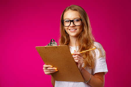 Young beautiful smiling woman standing and holding clipboard