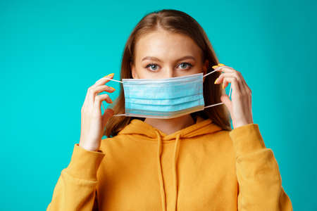 Young beautiful casual woman wearing protective medical maskの写真素材