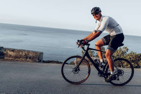 Cycling sport athlete man riding on coastal road