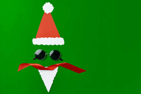 Santa face made of paper and sunglasses top view