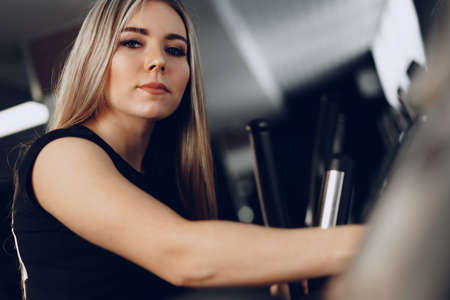 Attractive young blonde woman exercising on cardio training apparatusの写真素材