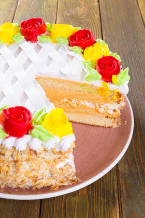 Cut biscuit cake on plate on wooden table