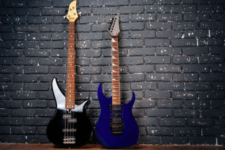 Electric guitar in neon light against dark walll