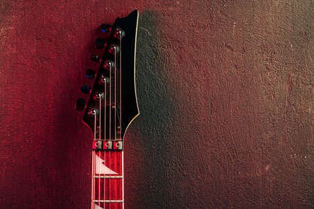 Guitar headstock with tuners on dark background