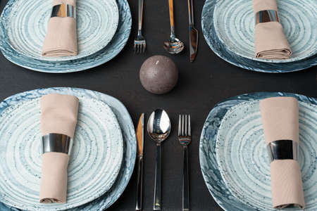 Table setting. Plates with abstract pattern on black tableの写真素材