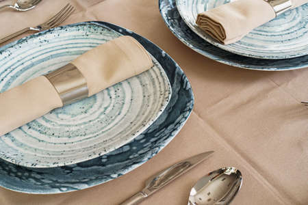 Details of a stylish table setting with textured ceramic dishes