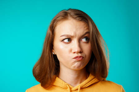 Studio portrait of beautiful young casual woman thinking