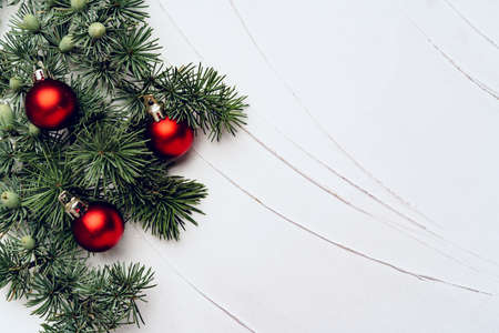 Christmas tree branches decorated with baubles on white backgroundの写真素材