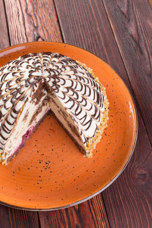 Cut caramel cake on plate on wooden table