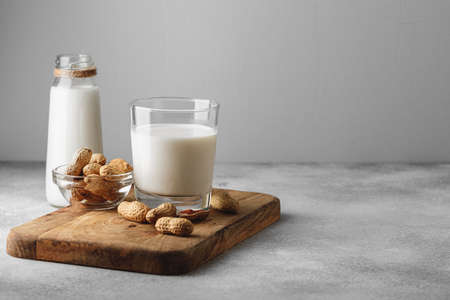 Vegan peanut milk in glass with peanutsの写真素材