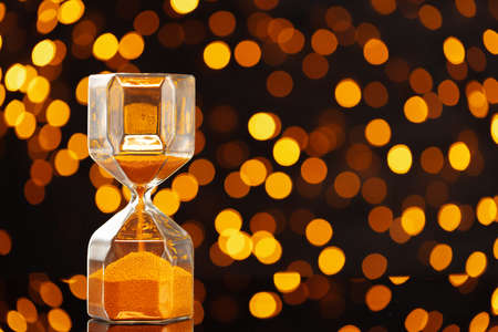 Golden hourglass against bokeh lights, Christmas background