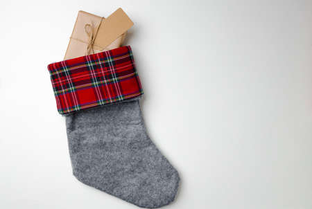 Christmas stocking with wrapped gift on white background