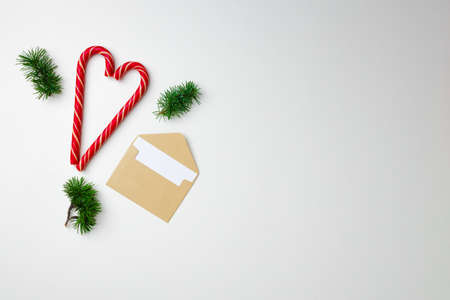 Candy canes and coniferous branches on white background