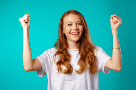 Happy cheerful excited young woman celebrating her success