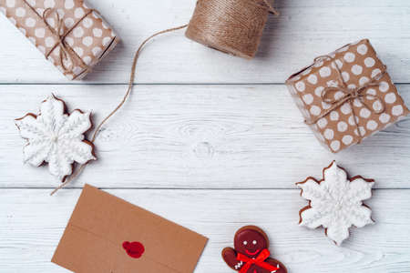 Wrapped Christmas gifts on white wooden board, top view