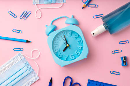 Blue alarm clock and medical face mask