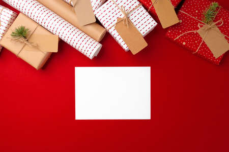 Christmas preparations concept with wrapping paper, gift boxes on red background