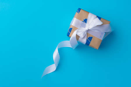 Top view of gift box with ribbon on blue background