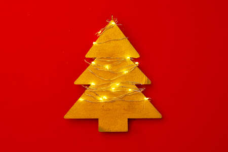Wooden Christmas tree decoration with lights on red background