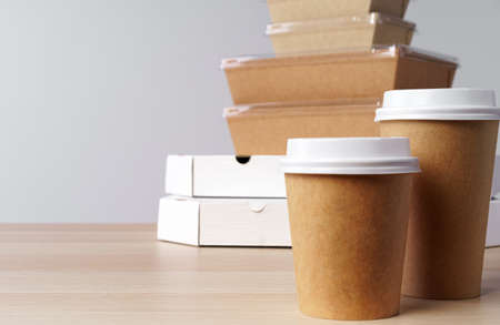 Many various take-out food containers, pizza box, coffee cups and paper bags on light grey backgroundの写真素材