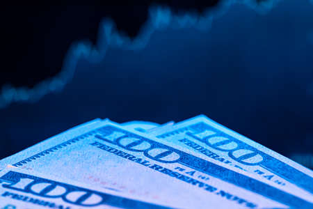 Dollars in front of a monitor with a price chart. Forex and trading.の写真素材