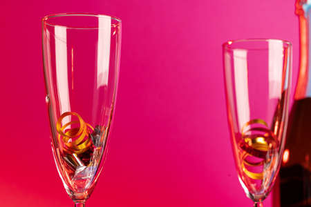 Champagne glasses with party tinsel on bright backgroundの写真素材