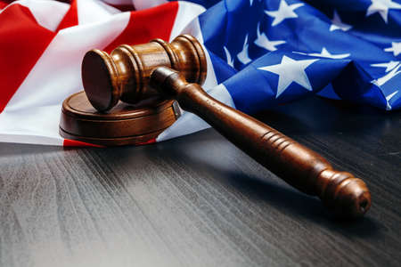 Gavel on wooden table with USA flag