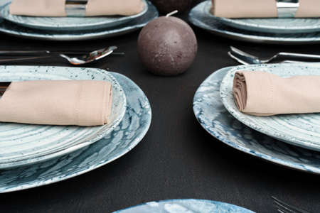 Table setting. Plates with abstract pattern on black table
