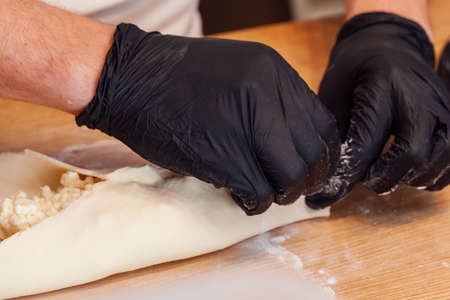 Cook hands preparing khachapuri in a cafe close upの写真素材