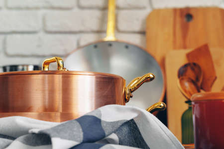 Copper cookware with wooden kitchen utensils close upの写真素材