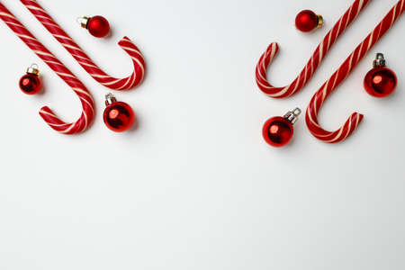 Candy canes and red Christmas baubles on whiteの写真素材
