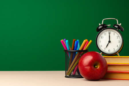 Pile of books and red apple on deskの写真素材