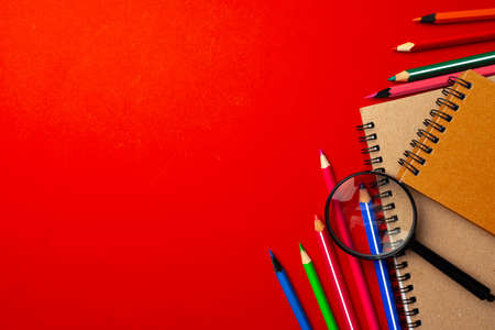 Colorful pencils and notepads on paper background top viewの写真素材