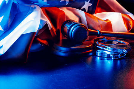Gavel, handcuffs and american flag on dark backgroundの写真素材