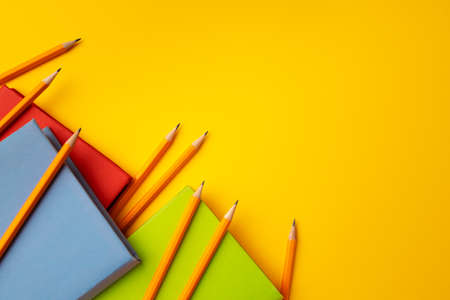 Notepad and color pencils on working space top view