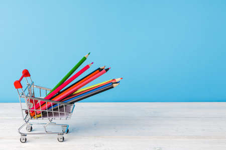 School supplies on wooden desk against blue backgroundの写真素材