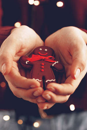 Female hands holding gingerbread man close upの写真素材
