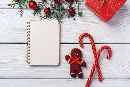 Winter festive background with gingerbread man and candy canes on white wooden boardの写真素材