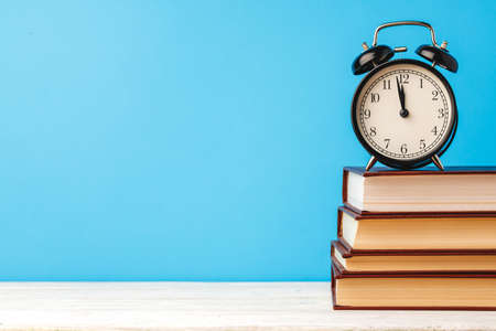 Books and alarm clock on table, education conceptの写真素材
