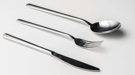 Spoon, fork and knife on a white background
