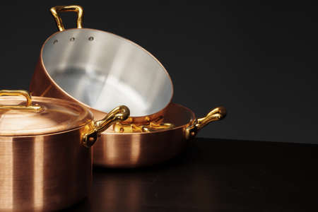 Set of copper cookware over dark background