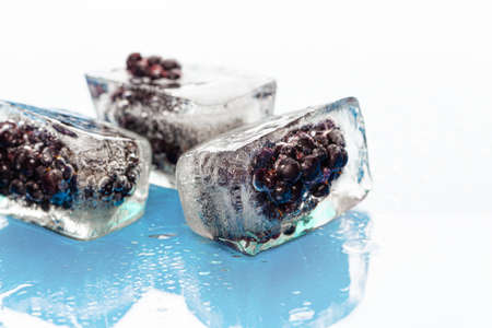 Ice cubes with frozen berries inside close upの写真素材