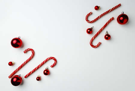 Candy canes and red Christmas baubles on whiteの写真素材